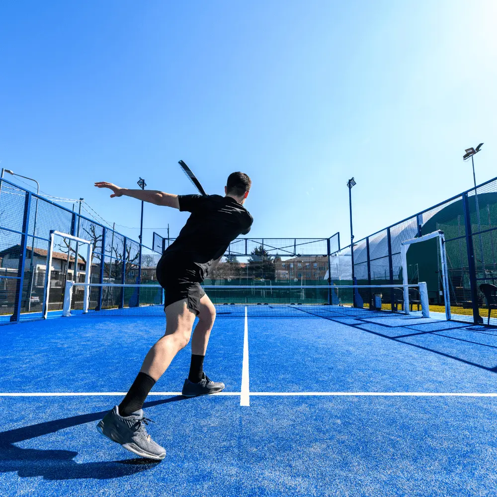 Joueur de padel en action sur terrain bleu